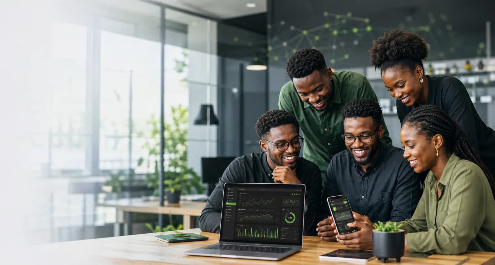 Equipe africaine moderne analysant des dashboards sur laptop et smartphone